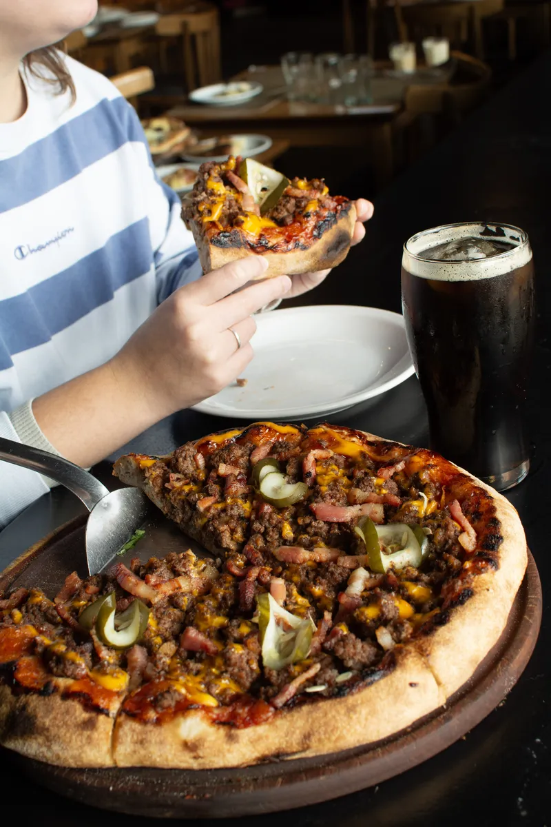 Pizza al horno de barro con leña encendida.